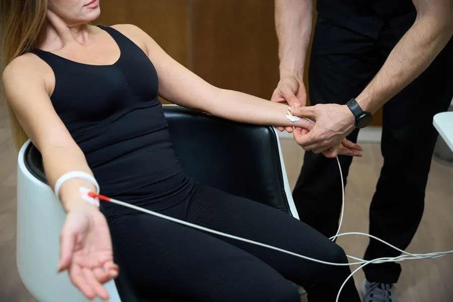 Specialist attaching electrodes to a patient's wrist for EMG nerve testing